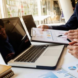 Business concept. Business people discussing the charts and graphs showing the results of their successful teamwork. Selective focus.