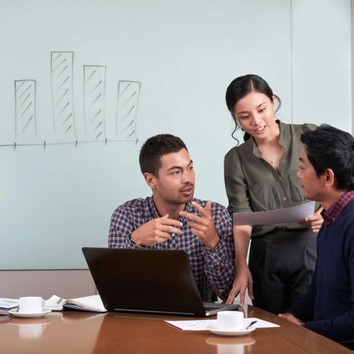 Group of young coworkers discussing project together